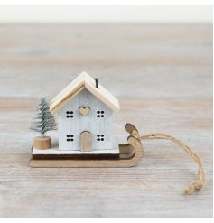 Add a charming touch to your festive decorations with this delightful wooden sleigh and mini house ornament.