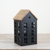 A gorgeous black iron house with cut out windows, complete with a wooden roof