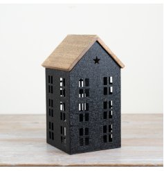 A gorgeous black iron house with cut out windows, complete with a wooden roof