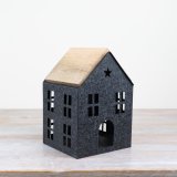 A charming iron house with cut out windows and a wooden roof.