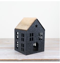 A charming iron house with cut out windows and a wooden roof.