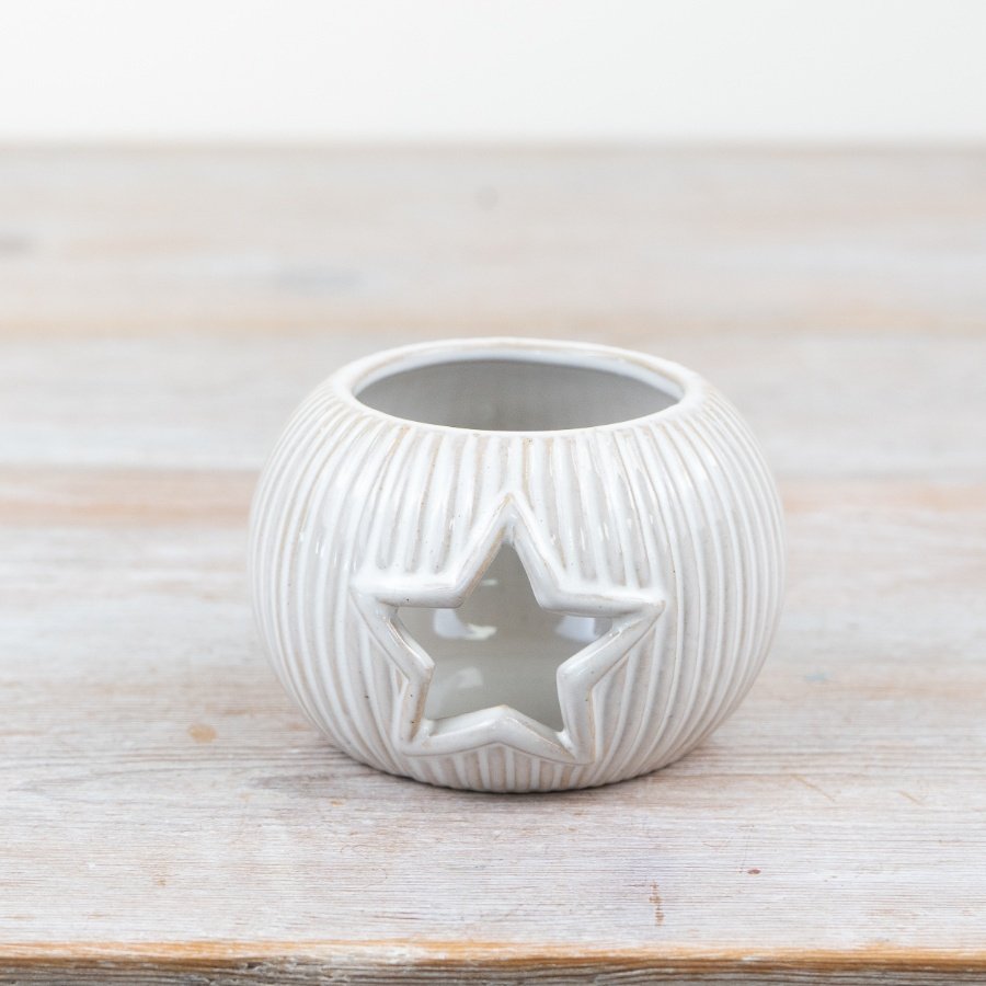 Add a touch of elegance to your home with this porcelain candle holder featuring a star cut-out design.