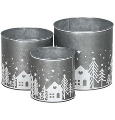 A chic set of 3 metal planters each with a festive Christmas scene pattern around the bottom.