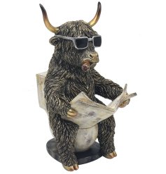 quirky highland cow ornamnet sat on the loo 