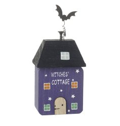 A striking purple wooden house with spooky Halloween detailing. 