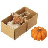 A charming candle set featuring two pumpkin shaped candles wrapped in cardboard packaging with jute twine