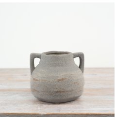 Add a touch of charm to your home décor with this rustic vase featuring two handles for easy carrying.