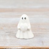 A sweet ghost figure holding a heart with a white glaze finish.