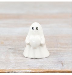 A charming ghost holding a heart, adorned with a smooth white glaze finish.