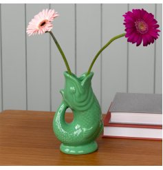 A stylish vase in the shape of a fish in a striking green colour. 