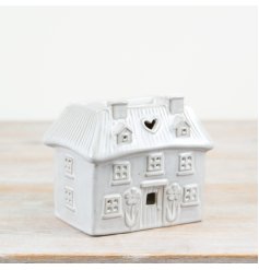 A unique cottage shaped oil burner. Beautifully detailed with hearts and flowers. Complete with a natural, glossy glaze.