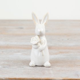 A chic standing rabbit ornament holding a flower. Beautifully detailed with glazed and unglazed elements.