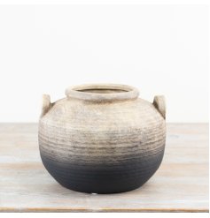 An artisan terracotta pot with a rustic surface and imperfect details, which enhance the character and charm of the item