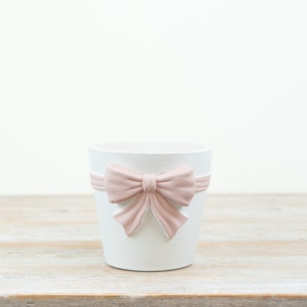 White planter featuring a large pastel pink bow for a chic, minimalist look.
