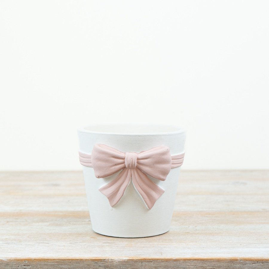 White planter featuring a large pastel pink bow for a charming, minimalist look.