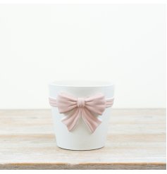 White planter featuring a large pastel pink bow for a chic, minimalist look.