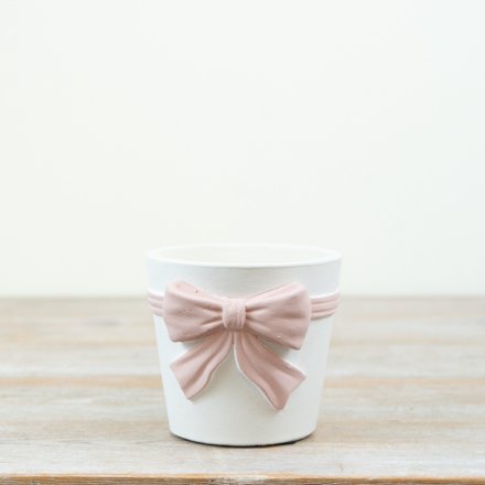 This stylish pink and white bow planter makes a bold and charming statement.