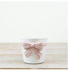 This stylish pink and white bow planter makes a bold and charming statement.