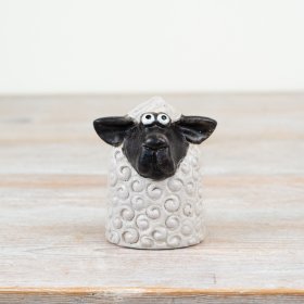 Enhance your spring decor with this stylish black and white Sitting Sheep ornament.