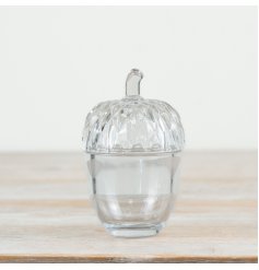 A glass acorn pot featuring intricate cut outs on the lid, an ideal pot for storing nuts or treats! 