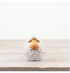 Fluffy sheep with a delicate pink flower in mouth. Adorable farmhouse decoration.