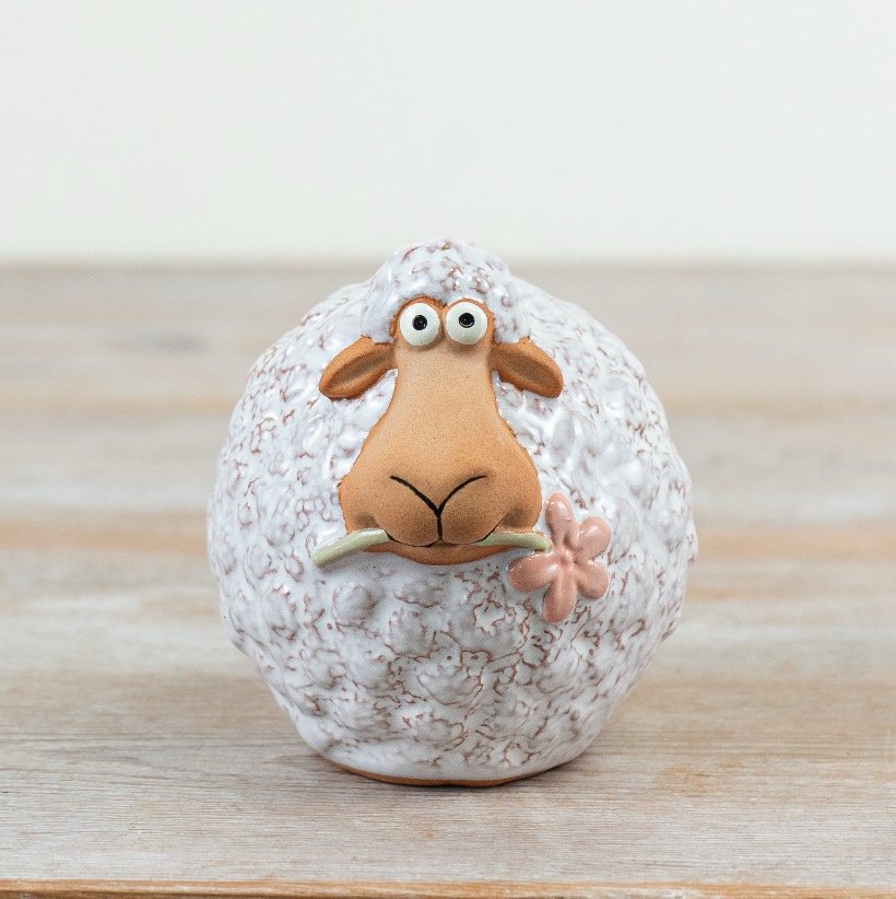 Adorable sheep with a pretty pink flower in its mouth. Made of soft wool. Perfect for animal lovers. 