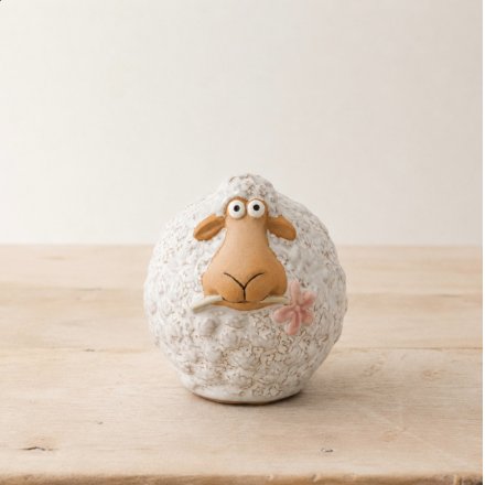 Fluffy sheep with a delicate pink flower in mouth. Adorable farmhouse decoration.