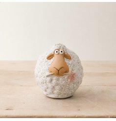 Fluffy sheep with a delicate pink flower in mouth. Adorable farmhouse decoration.