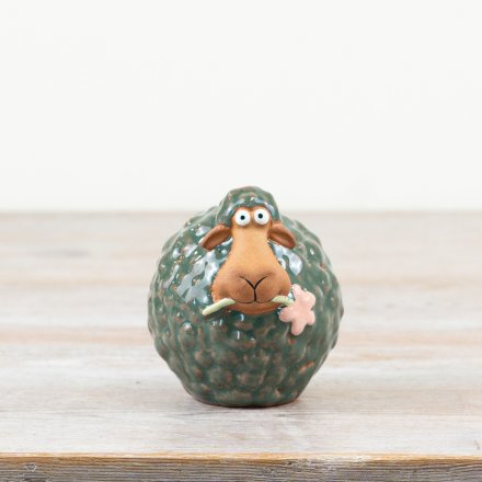 Delightful green sheep figurine made of porcelain, holding a delicate flower.