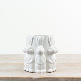 A delightful white vase adorned with cute rabbits all around.