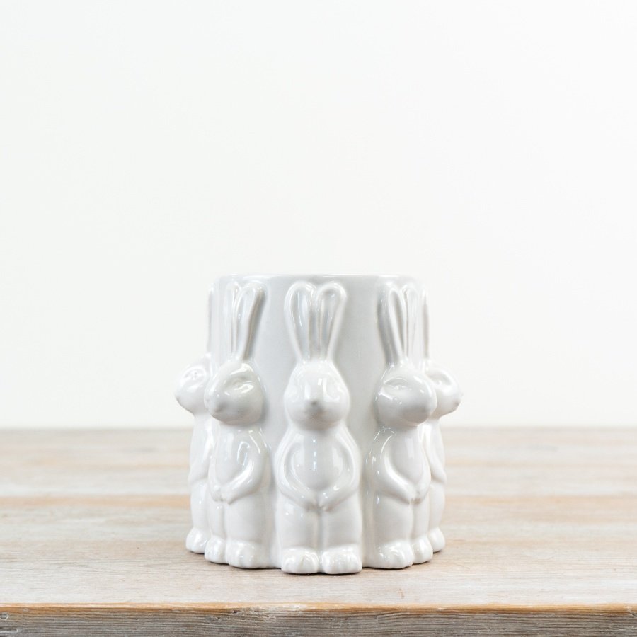 A delightful white vase adorned with cute rabbits all around.