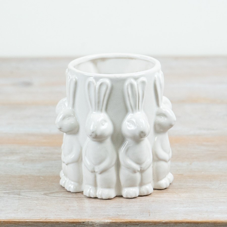 A delightful white vase adorned with cute rabbits all around.