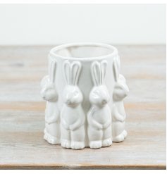 A charming white vase surrounded by adorable rabbits.