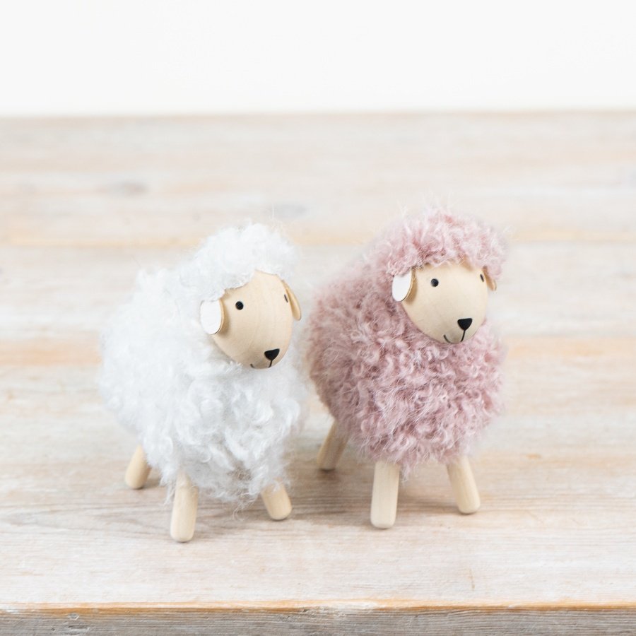 A soft assortment of three woolly sheep in gentle neutral shades.