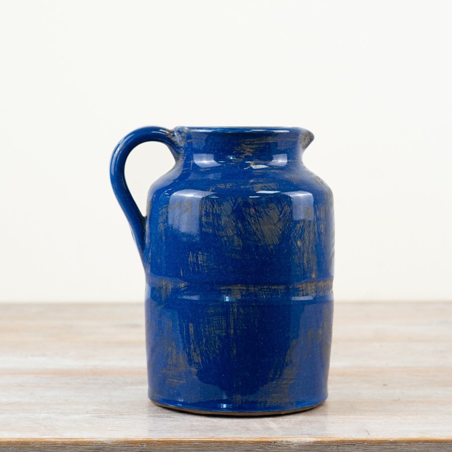 A charming ceramic pitcher in a luxurious deep blue glaze. A rustic item with plenty of character and charm. 