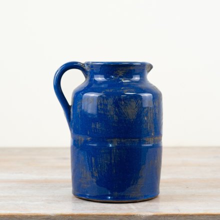 A stunning ceramic pitcher with a rustic finish and deep blue glaze.