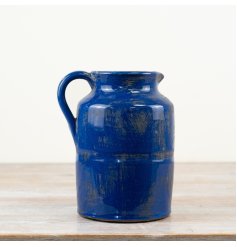 A stunning ceramic pitcher with a rustic finish and deep blue glaze.