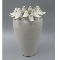 Delightful bird perched on the rim of a natural-toned vase.