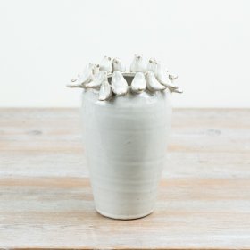 Delightful bird perched on rim of a natural-toned vase.