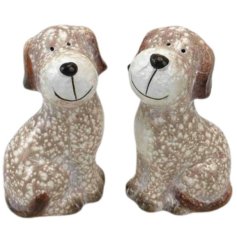 Elevate your décor with two adorable dog ornaments in a warm brown and neutral hue. Perfect for a woof-ly display.