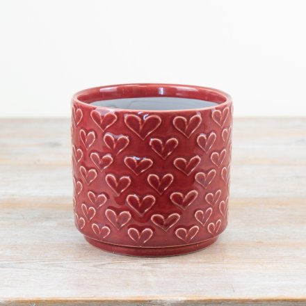 Create a calm and serene space with this chic red planter with an embossed heart pattern. 