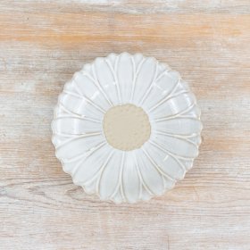 A pretty porcelain dish with a daisy pattern featuring a rich white glaze and raw details. 