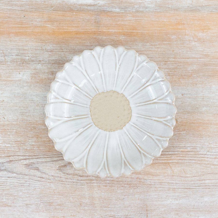 A pretty porcelain dish with a daisy pattern featuring a rich white glaze and raw details. 