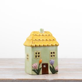 Delightful green candle shaped like a floral house for a cozy, decorative touch.
