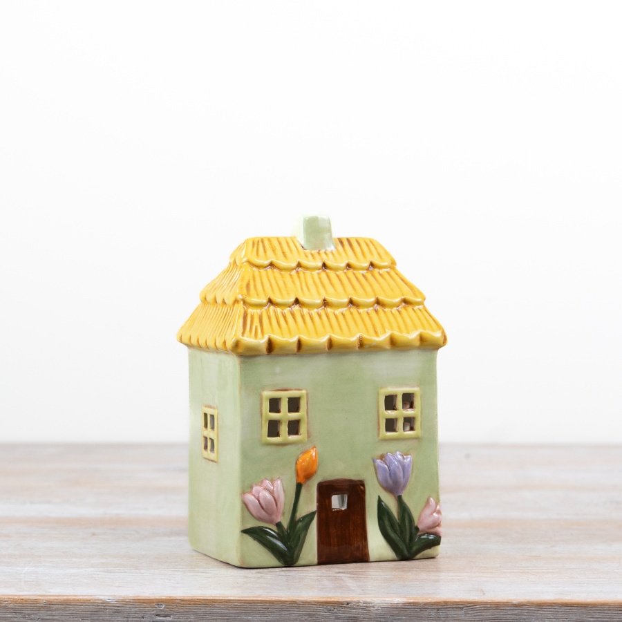Delightful green candle shaped like a floral house for a cozy, decorative touch.