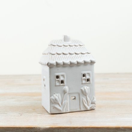 Delightful green candle shaped like a floral house with a charming design.