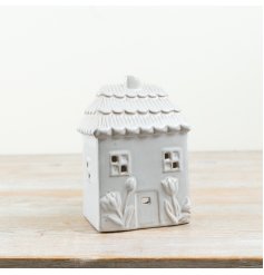 Delightful green candle shaped like a floral house with a charming design.