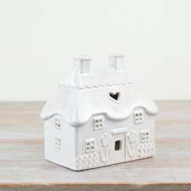 Elegant tea light holder shaped like a neutral-toned house, perfect for stylish decor.