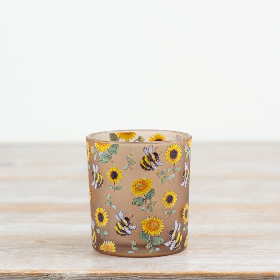 Illuminate your room with this lovely glass candle holder featuring intricate sunflowers and bees.
