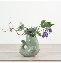 Bring charm to your space with this chic sage green fish-shaped vase.